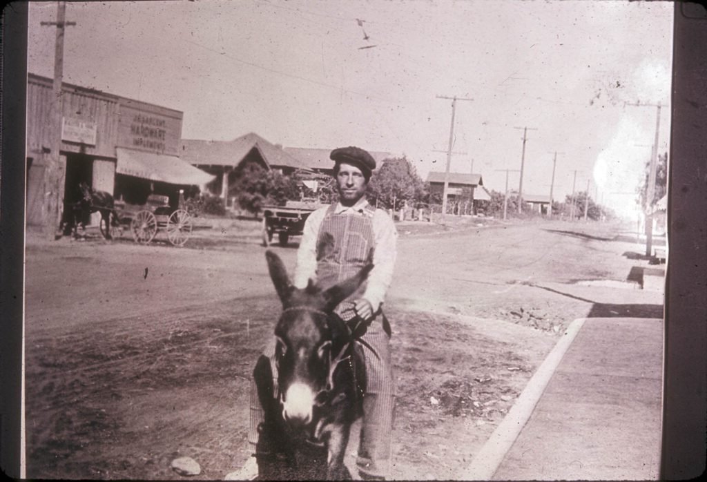 Image of Dooley Davis riding a mule (Jack), looking northeast at Central Avenue, 1914.