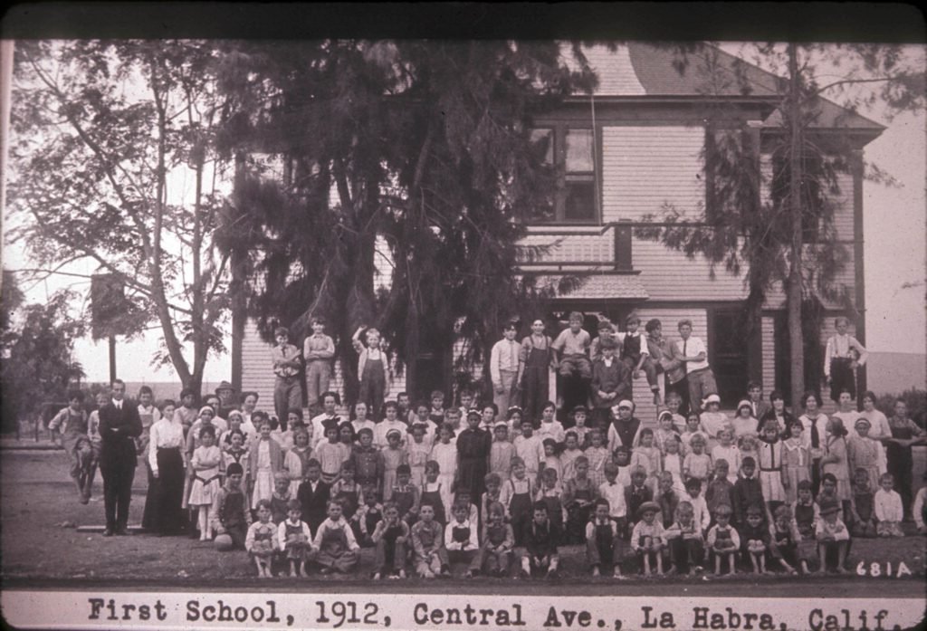 A group portrait in front of La Habra School, located on Central Avenue, La Habra, Calif., in 1912. The school was built in 1896 and was used for classes and community events. It was later renamed La Habra Grammar School and replaced with a new building in 1915.